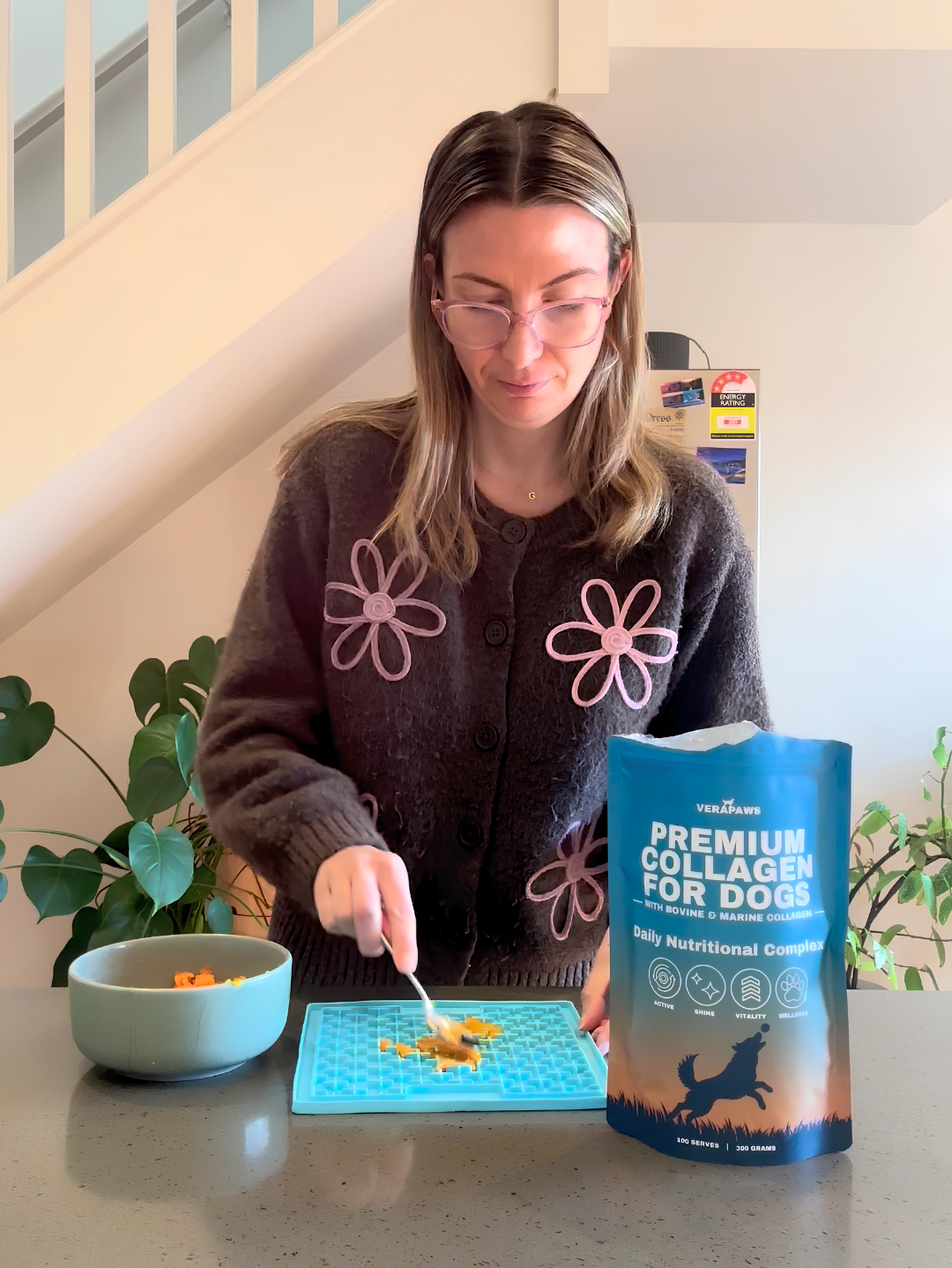 Woman with a spoon full of VeraPaws Collagen For Dogs powder.