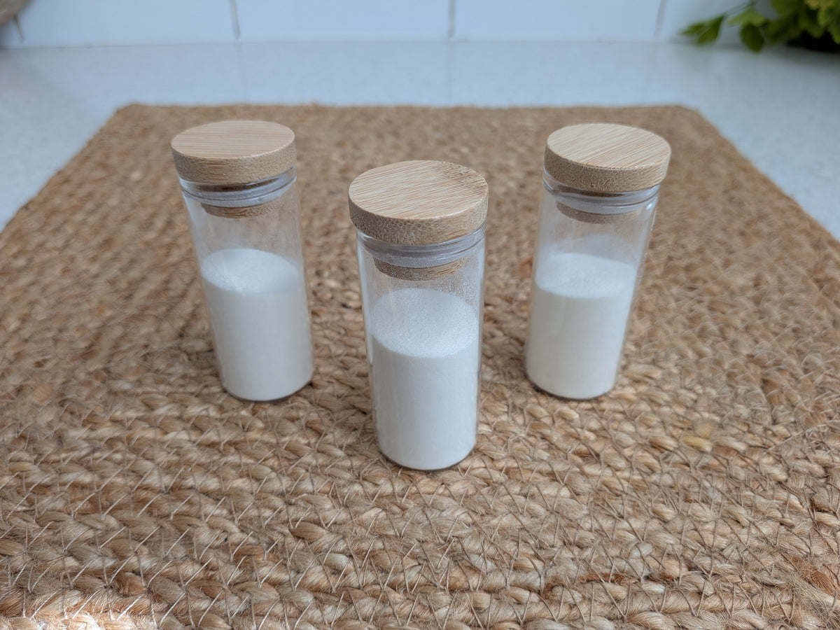 Three vials of collagen powder on a jute mat
