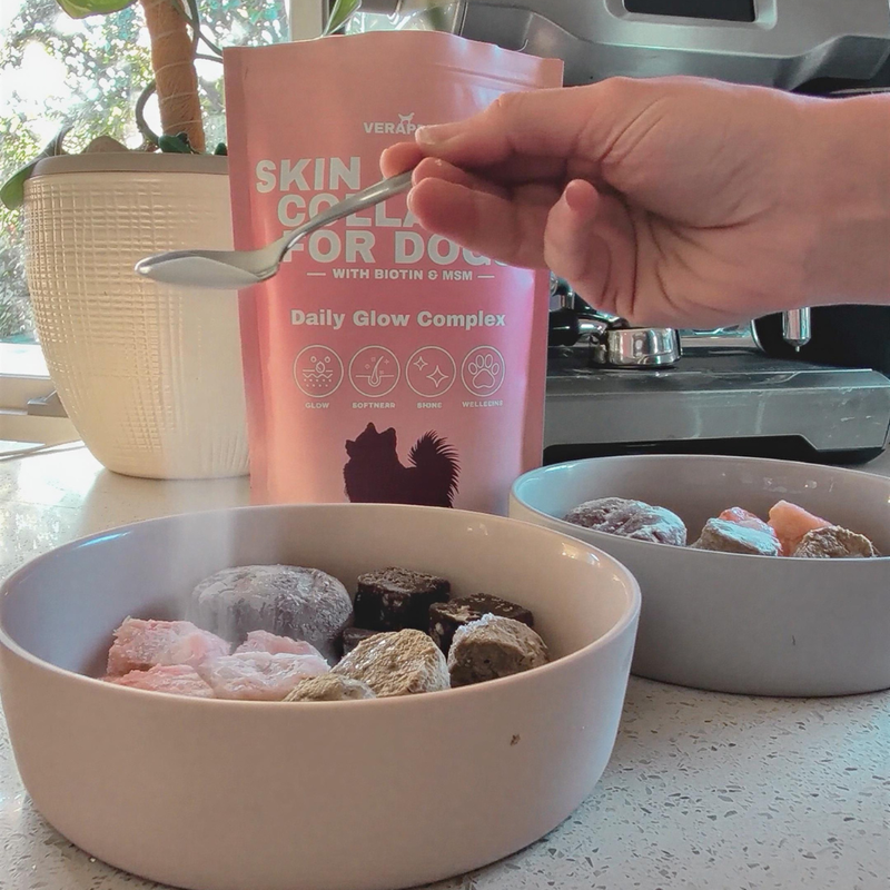 A spoon of Skin and Coat Collagen For Dogs sprinkled over dog food.